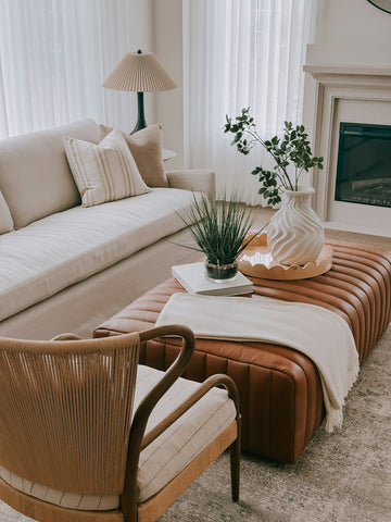 A modern living room with a leather ottoman and sofa