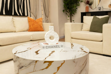 Modern living room with marble coffee table and cream sofas.