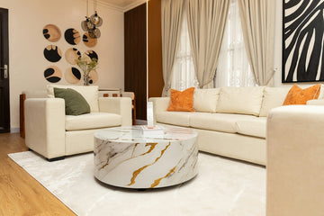 Elegant living room featuring white sofa, armchair, and marble table.