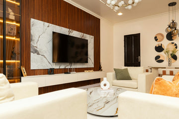 Modern living room with tv, white sofas, and marble accents.