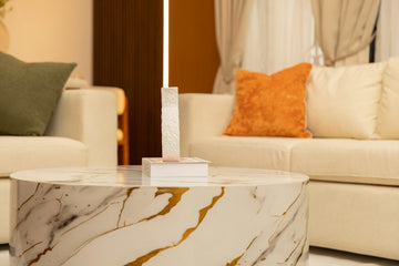Elegant living room with marble coffee table and cream sofas.