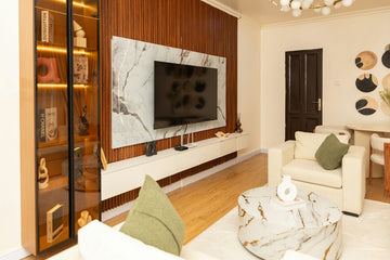 Modern living room with tv, white sofa, and marble table.